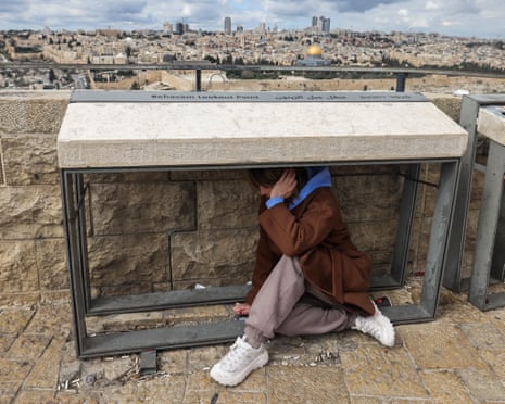 A person takes shelter as sirens sounded in Jerusalem.