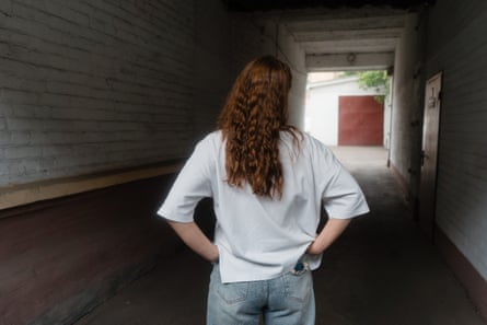 Marina, wearing white top and jeans, with her back to camera.