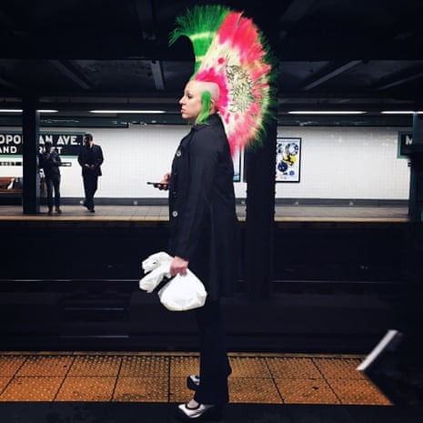 Women with green and pink hair in the shape of a fan on platform in New York subway