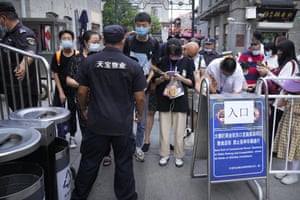 People scan health check codes with their smartphones to show to a security guard at a tourist shopping street in Beijing.