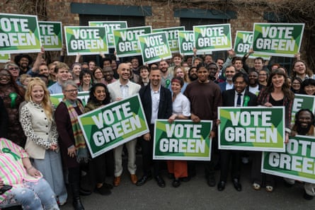 Green Party candidates and supporters holding up signs that say 'Vote Green'