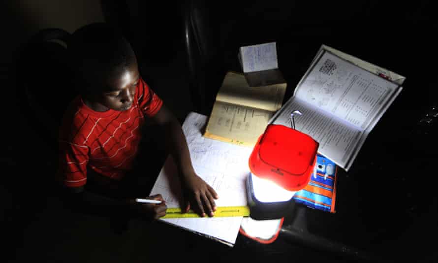 A student does his homework using a solar lantern in Zimbabwe