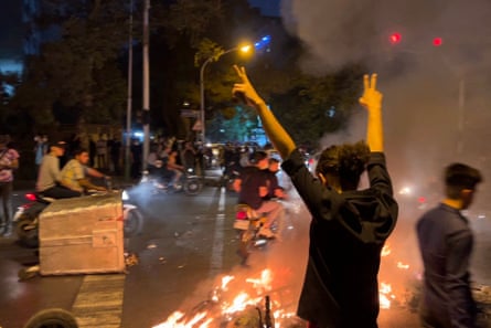 A demonstrator raises his arms and makes the victory sign during a protest.
