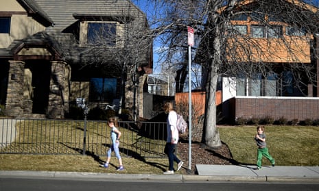 A family walks between sections of sidewalk and non-sidewalk in Denver