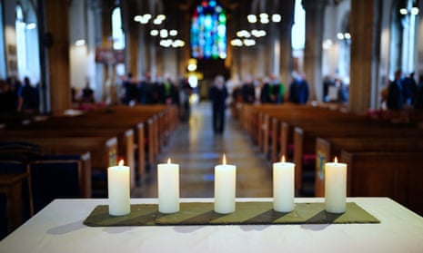 Five lit candles are seen on the altar after a civic service in the Keyham area of Plymouth to remember the five people killed by Jake Davison