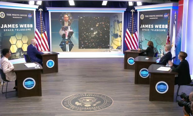 Biden, Harris i inni patrzą na ekran zza podium