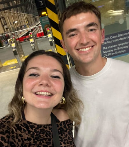 A selfie of a smiling young woman with long wavy brown hair and a leopard-print top, and a smiling young man with short brown hair and a beige T-shirt