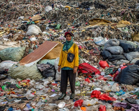 woman stands in front of mounds and mounds of litter