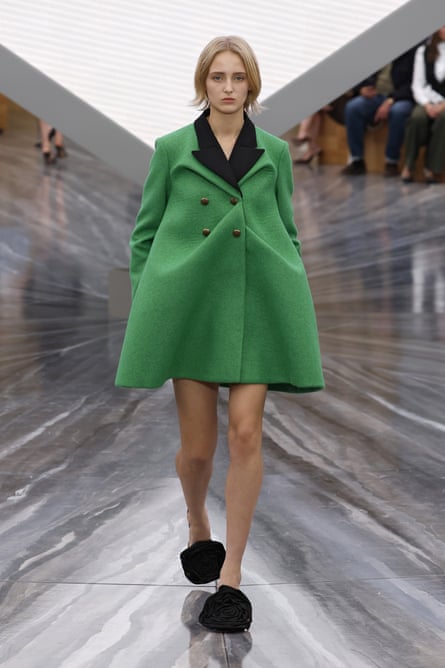 A model in a short green smock coat