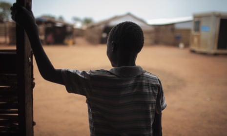 Thirteen-year-old Batista was drugged and raped in the middle of the night. He stands in the doorway of a psychosocial support clinic in a camp for the internally-displaced in Wau, South Sudan. 