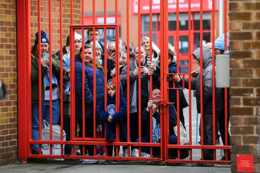 Manchester City fans watch the players arrive for the game.