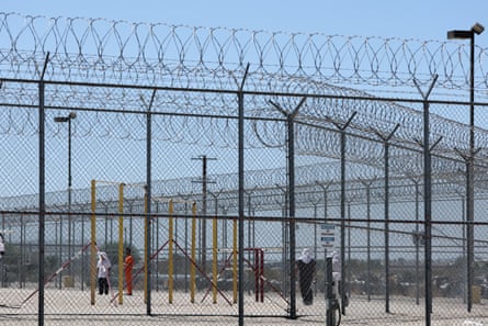 Detained people are seen behind fences at the Adelanto ICE detention facility in Adelanto, California.