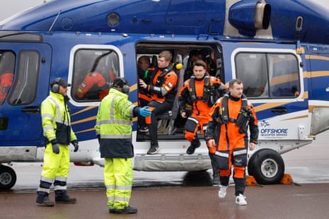 Oil workers arriving in Aberdeen today after being flown back to land by helicopter after a shift on a rig.