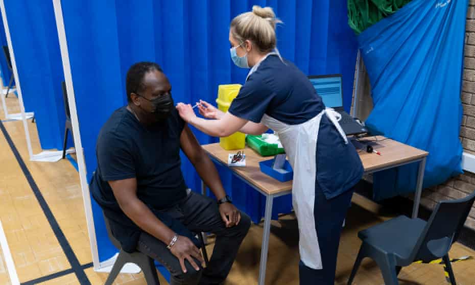 A health worker gives a Covid vaccine to a man in Barry, south Wales.