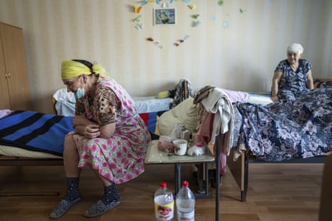 Vera Vasiukova, 71, left, sits on her bed at a centre for displaced people near Mykolaiv.