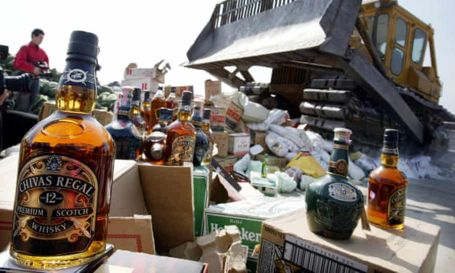 A bulldozer prepares to crush thousands of bottles of counterfeit alcohol during a public awareness campaign against counterfeit products in Shanghai, China. 