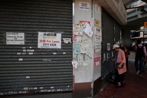 A woman stands in front of a closed shop available for lease in Hong Kong, China, October 29, 2019. REUTERS/Umit Bektas