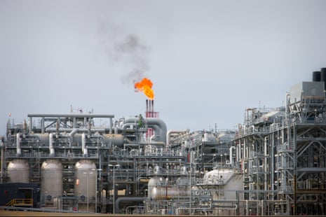 A flame blazes on top of flare stacks the Queensland Curtis Liquefied Natural Gas project site