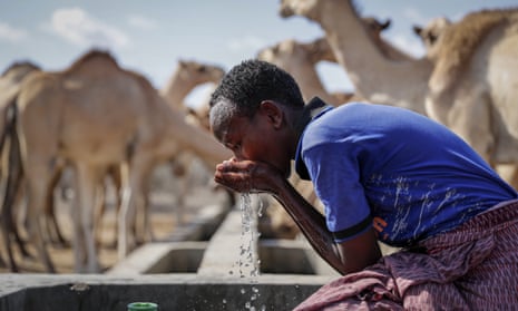 A boy who looks after livestock quenches his thirst from a water point near Dertu, Wajir County, Kenya