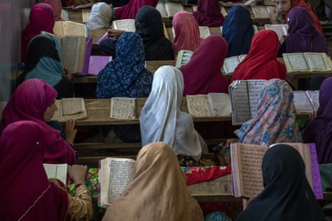 Afghan girls read the Qur'an outside the city of Kabul, Afghanistan