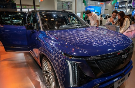 People look at a blue Cadillac on show