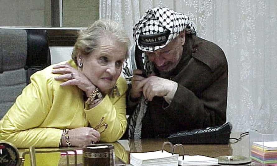 Madeleine Albright listens while the Palestinian leader Yasser Arafat talks to President Bill Clinton on the telephone during peace talks in Gaza City, 1999.