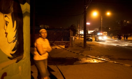 A woman walks past two men dead in a road after a shootout in Tijuana, Mexico, on 17 November 2008.