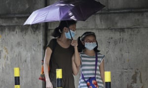 People wear masks as they pass by a Chinese-Filipino school in Manila that suspended classes as a precautionary measure against the virus on Monday.