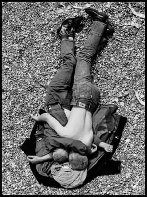 A couple embrace on Brighton beach on a bank holiday Monday in 1982