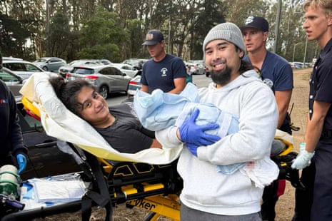 a man and woman smile with their newborn