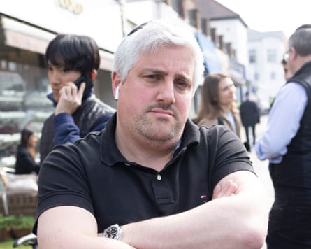 Adler stands with his arms crossed