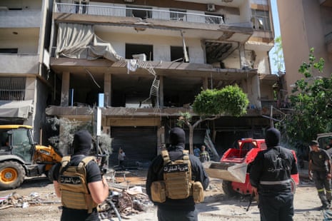 Lebanese army soldiers stand guard as people clear the rubble at the site of an Israeli airstrike that targeted a building in Beirut's southern suburbs on 14 June, 2026.