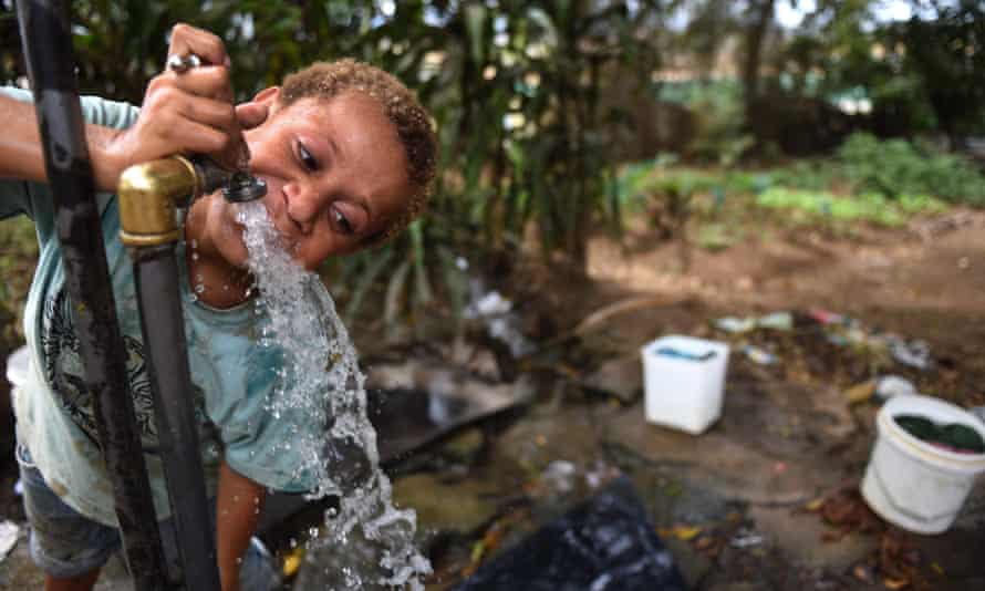 A child drinks water from the only tap for more than 100 people in a shanty town in the suburb of 9 Mile in Port Moresby, Papua New Guinea