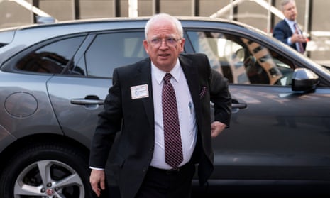 Eastman in a suit, exiting an SUV. 