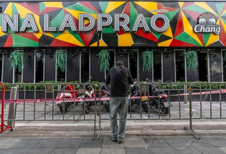 A mourner stands outside the Bangkok pub where dozens died in a fire on Monday.