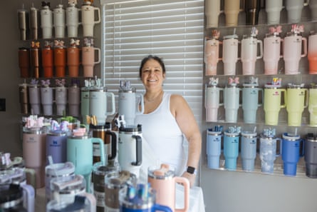 Mariana Conti Schwartz poses with her colorful collection of 103 Stanley tumblers in the dining room of her home in North Carolina.