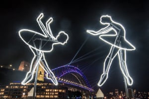 Two outlines of ballerinas constructed from neon lighting with the Harbour Bridge in the background