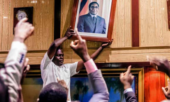 A portrait of Robert Mugabe is removed amid celebrations after his resignation