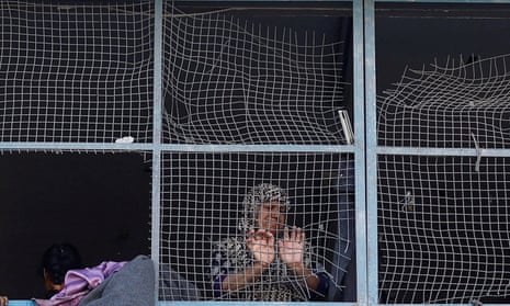 A Palestinian woman reacts near the damaged windows of a classroom in a UNRWA school, after an air strike on a house neighbouring the school in Khan Younis, in the southern Gaza Strip, June 21, 2024. REUTERS/Mohammed Salem TPX