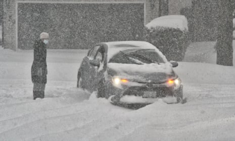  Woman figures how to free a car after it became stuck in the snow on a road as a massive snowstorm hit Toronto, Ontario, Canada.