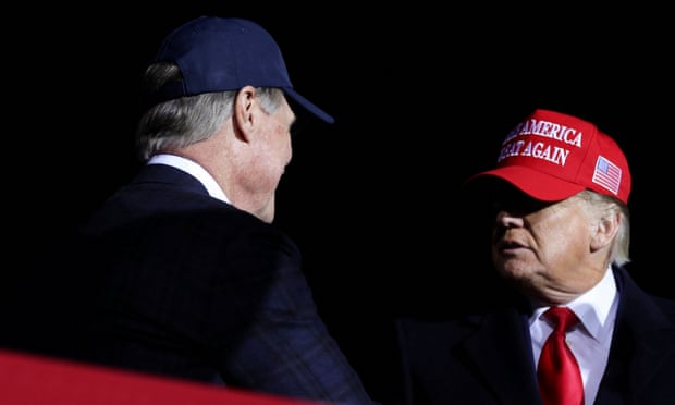 Former senator David Perdue salutes Donald Trump during a rally in Georgia in March 2022.