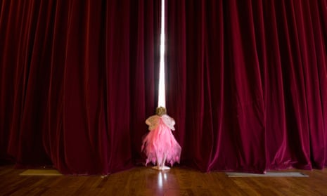 girl waiting behind theatre curtain to appear on stage