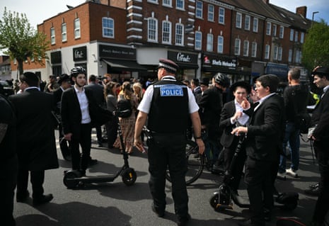 A police officer and members of the Jewish community near the scene of the stabbings.