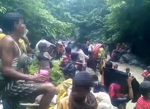 People apparently fleeing with their possessions in Myanmar