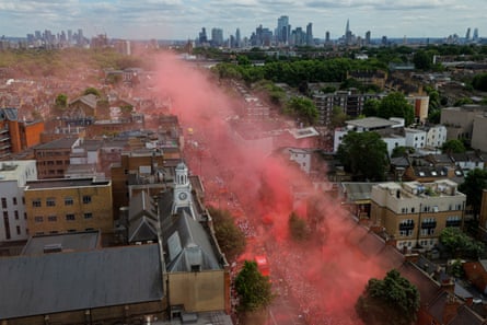 Taken from the top of London Metropolitan University, red smoke drifts above the Holloway Road with the city of London in the background as Arsenal start their trophy parade