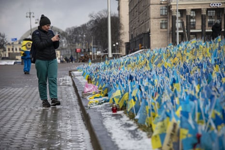 A civilian takes a photo of Ukrainian flags in Kyiv dedicated to those who lost their lives during the war.