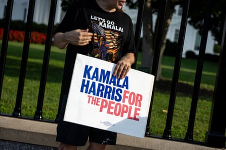 A man wearing a “Let’s Go Kamala” shirt holds a sign supporting US vice-president Kamala Harris along Pennsylvania Avenue in front of the White House in Washington DC.