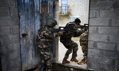 Ukrainian soldiers walk through a building during a training exercise with French soldiers at a French military camp in France