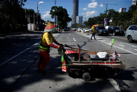 Alejandro Galasao, 58, street sweeper, pushes a cart with cleaning supplies in Quezon City