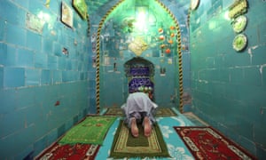 A man prays inside the shrine of Imam Mahdi at the Wadi al-Salam cemetery.